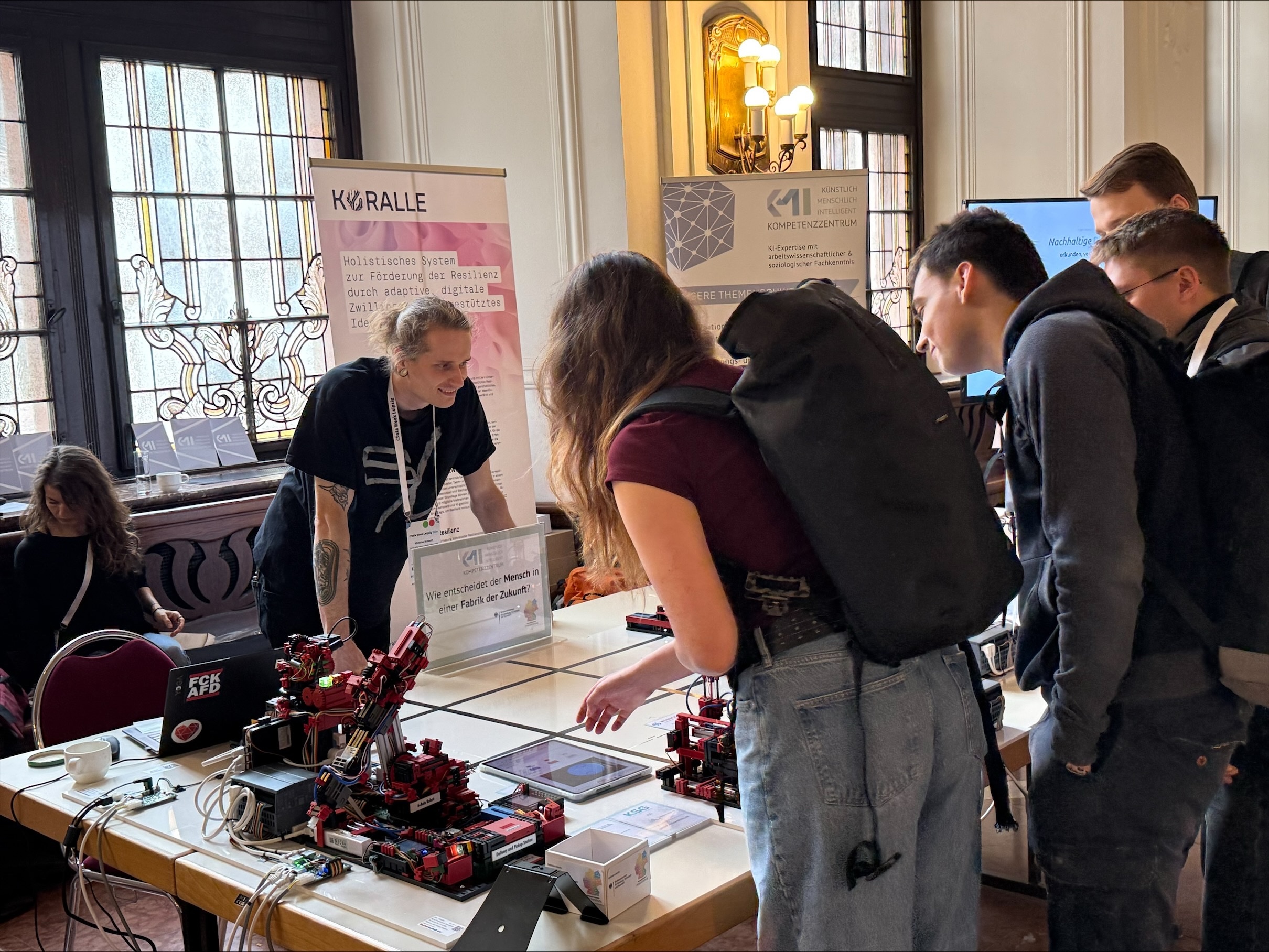 KMI Standansicht. Austausch mit Teilnehmenden am Stand.